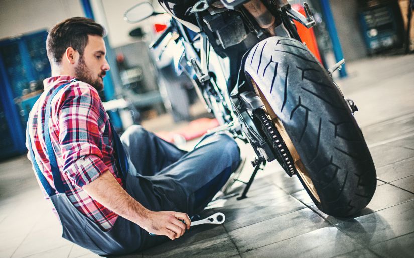 Hombre revisando la motocicleta en un taller